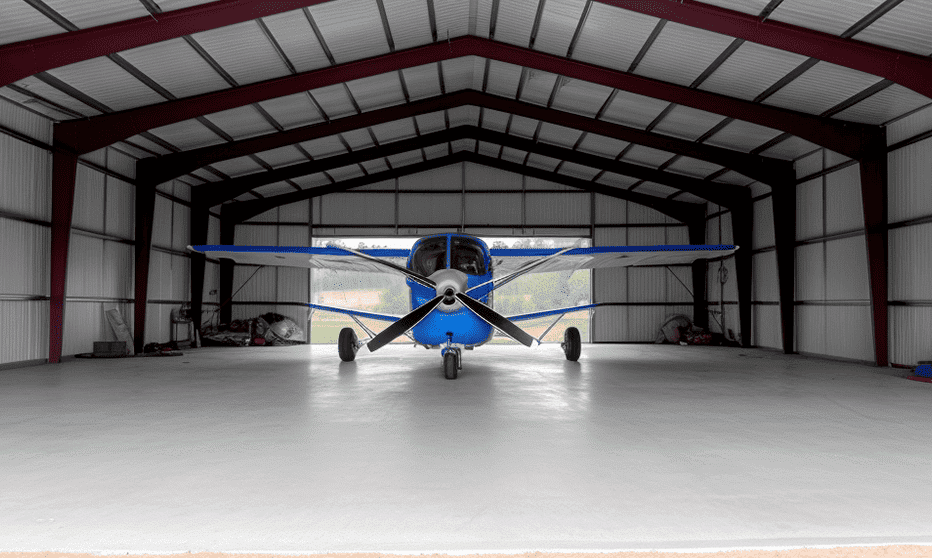 Modern steel-framed building with airplane sculpture displayed prominently